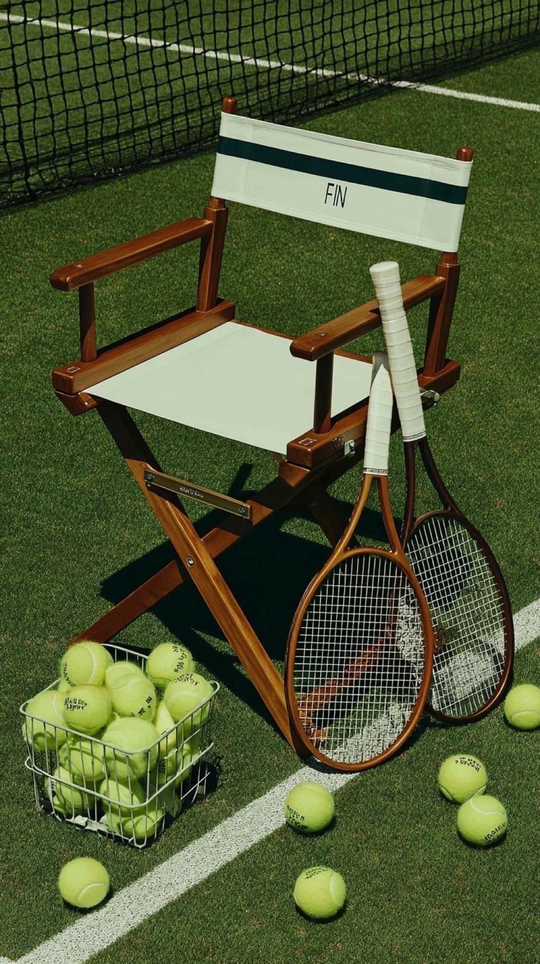 Tennis rackets, chair and basket of balls
