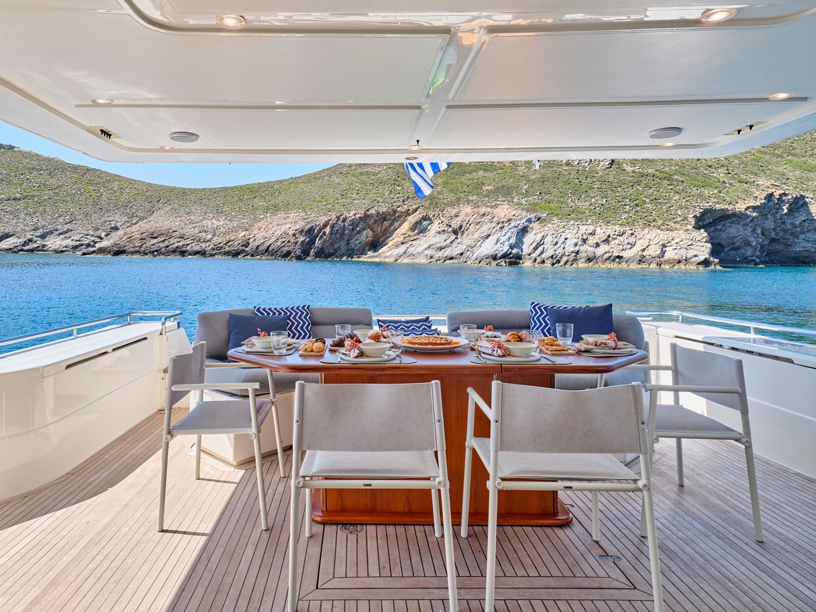 Aft deck dining on Apeiron Blue in a cove
