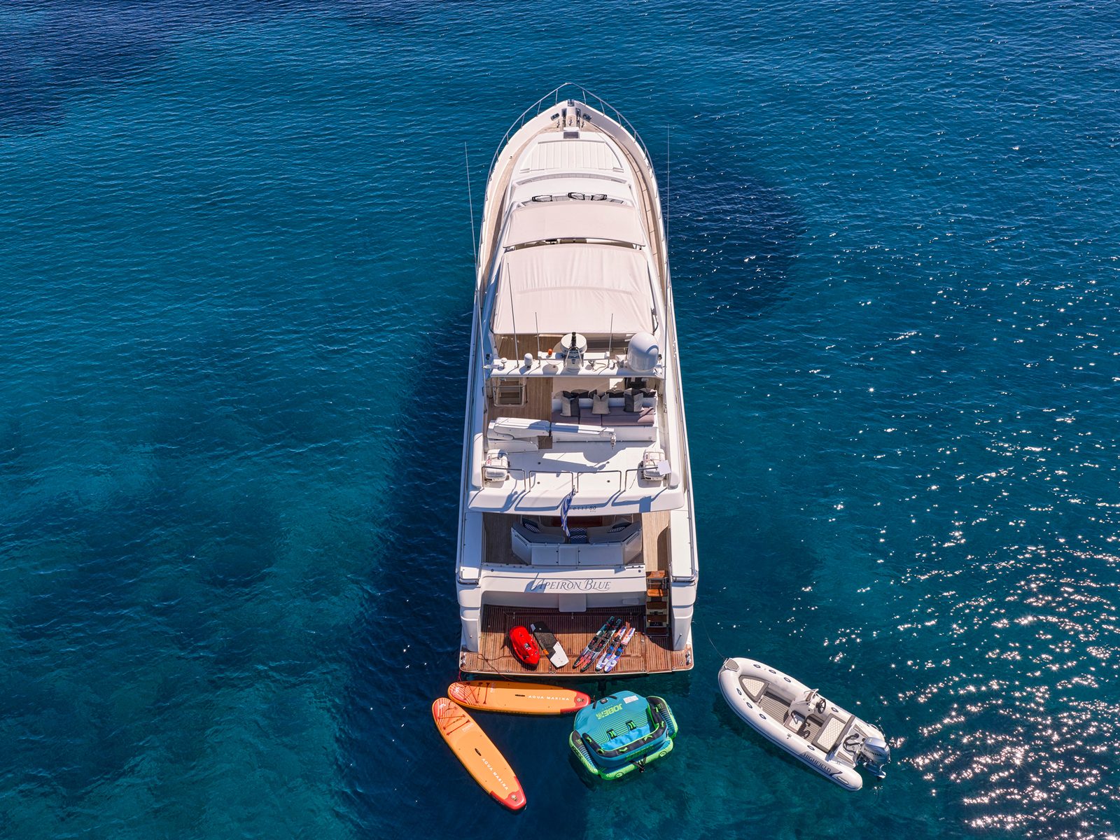 Apeiron Blue from above with paddleboards, SeaBob and tender off the stern